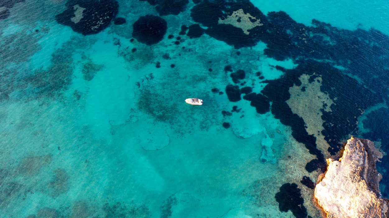 Vista aérea de aguas turquesas con rocas y posidonia en la Isla de la Olla en Altea Costa Blanca