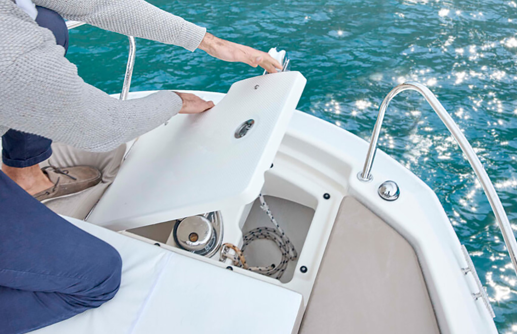 Persona abriendo tambucho de proa con molinete eléctrico en una Quicksilver Activ durante alquiler de barco en Altea