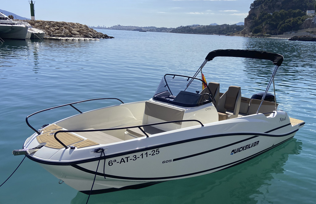 Quicksilver 605 Open con bimini recogido frente a la entrada de Marina Greenwich en Altea durante alquiler de barco