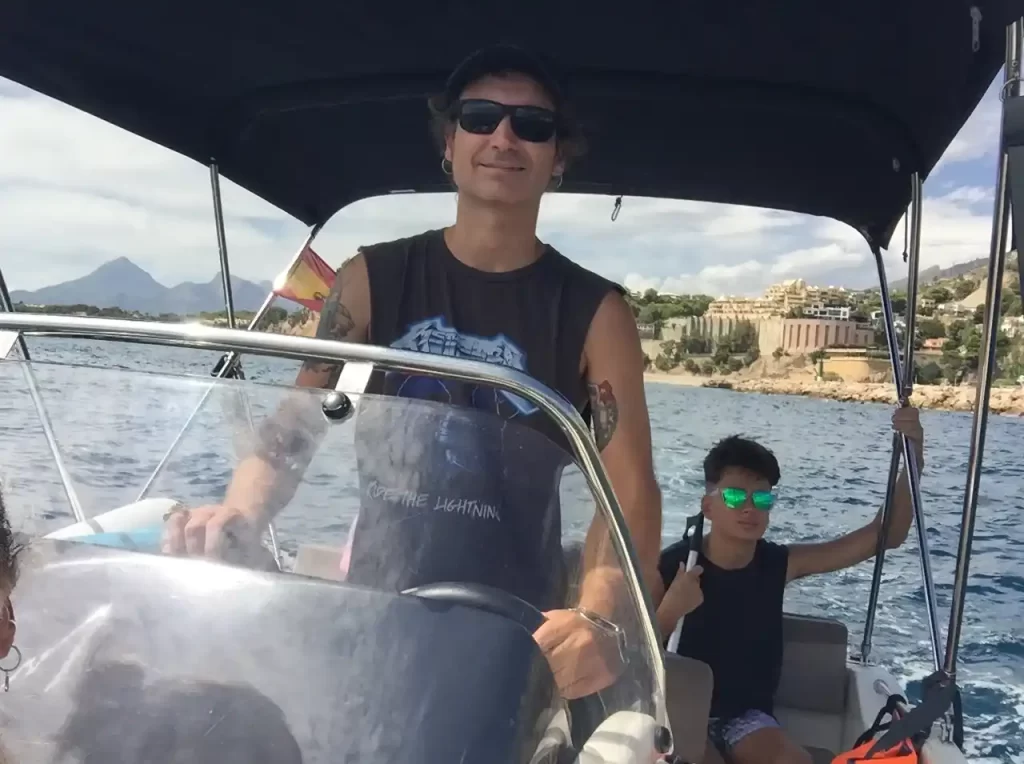 Father and son navigating on a Quicksilver Open boat along the coast of Altea with the father at the helm.