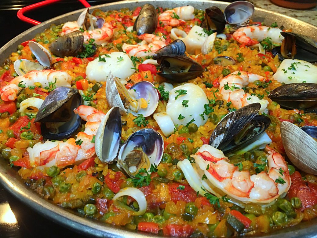 Paella de frutos del mar con gambas, almejas y calamar, plato típico de la gastronomía mediterránea para disfrutar en la Costa Blanca