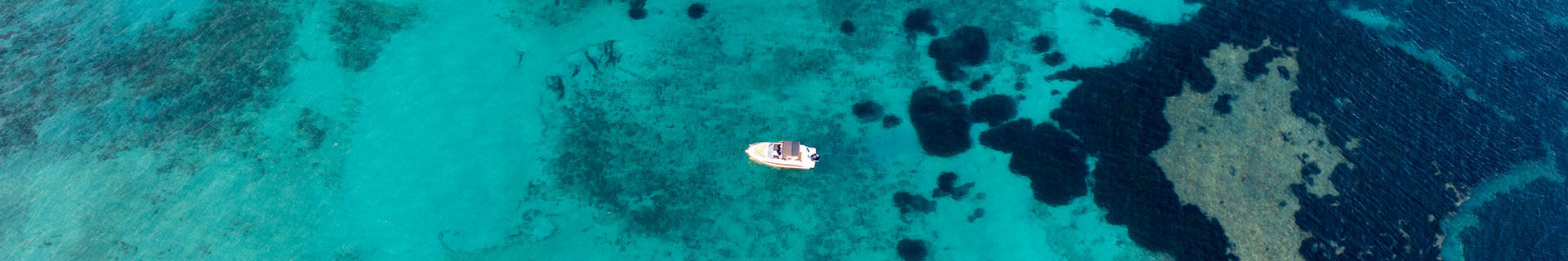 Vista aérea de un barco de alquiler navegando en aguas turquesas de la Costa Blanca, desde el Puerto Campomanes en Altea con Mawi Boats