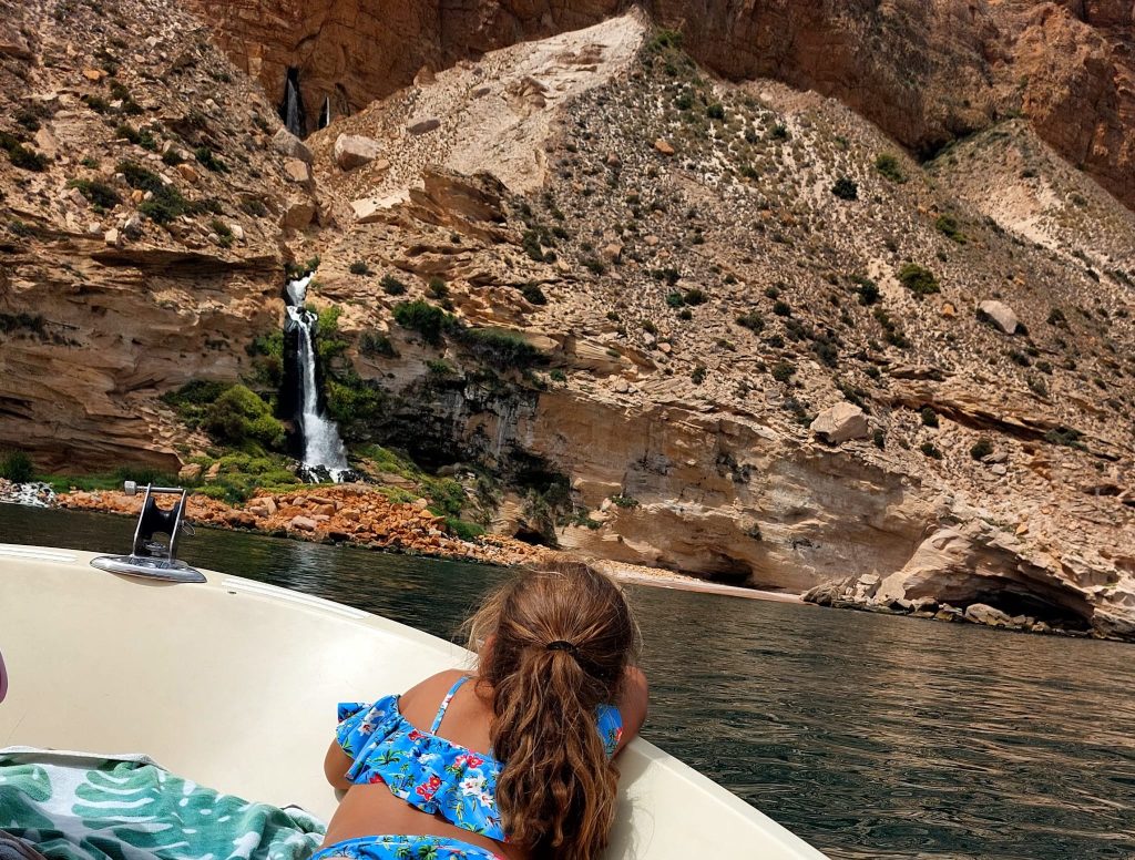 Niña observando la costa de la Serra Gelada desde la proa de una lancha en la Costa Blanca, zona protegida de fondeo responsable
