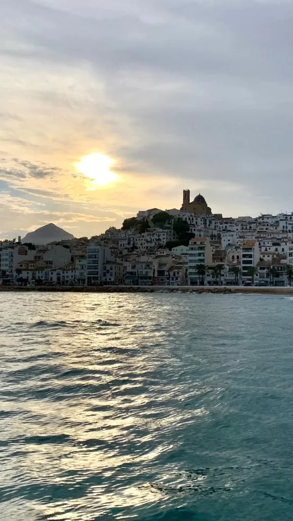 Sunset over the coastline of Calpe with the historic church of the old town visible on top of the hill on the Costa Blanca