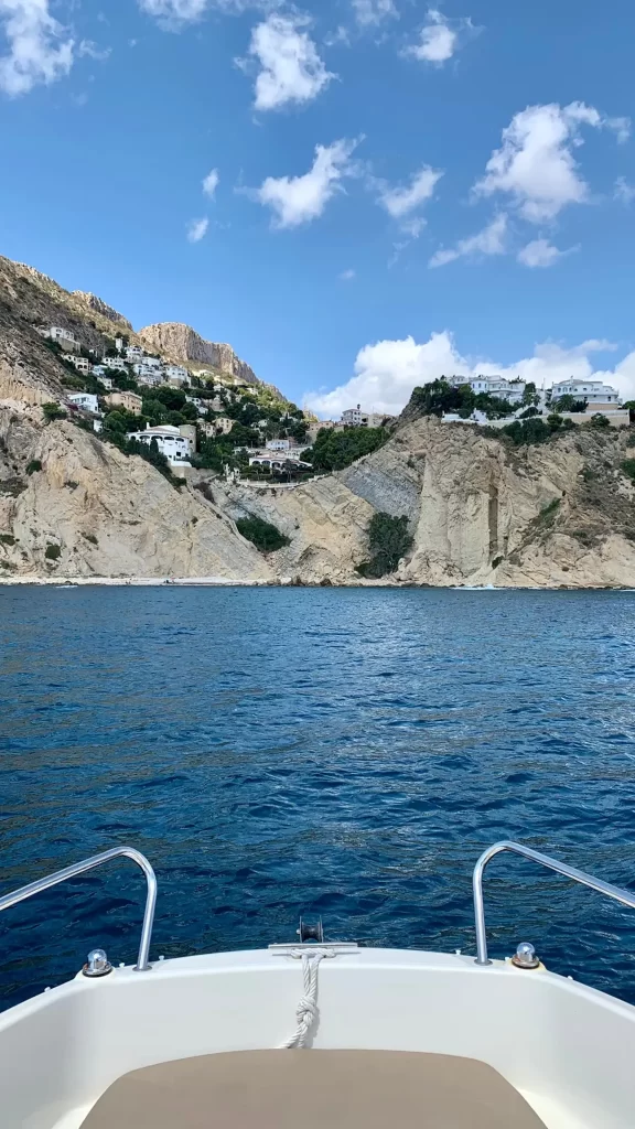 View of the Moraira coastline and houses on the cliffs from a Quicksilver 605 Open navigating on the Costa Blanca
