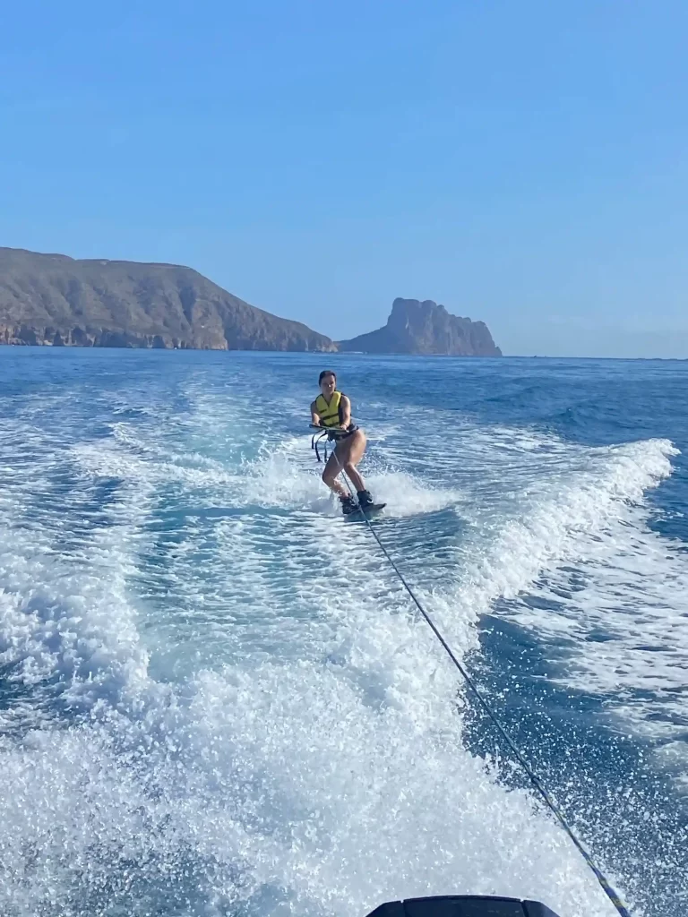 Woman wakeboarding in the sea with the Pe&ntilde;&oacute;n de Ifach and the cliffs of Calpe in the background on the Costa Blanca.