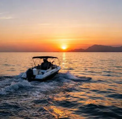 Boat at sunset during an ashes scattering ceremony at sea in Altea